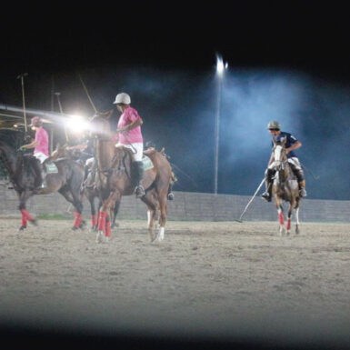 polo players in illuminated arena polo field at night night